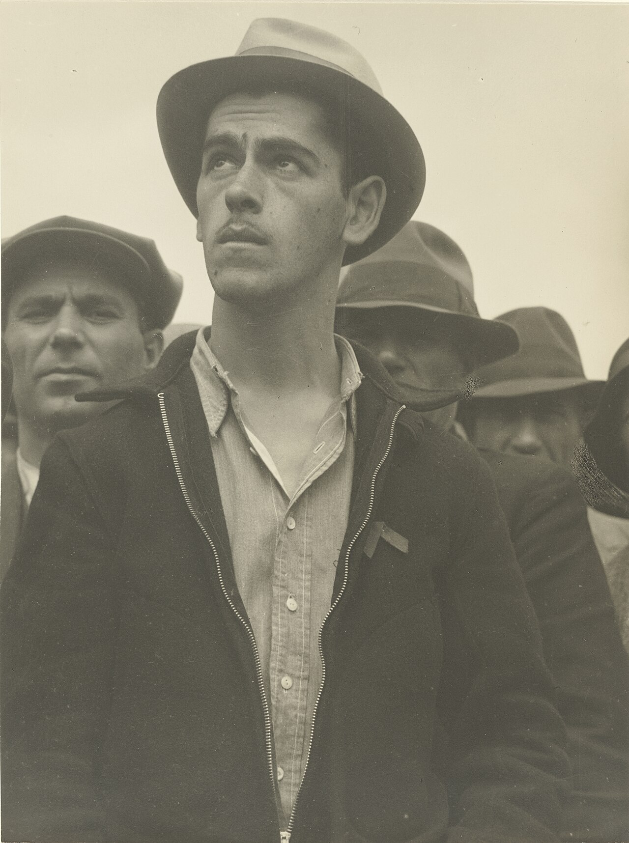 A young man looking upward intently in a crowd listening to a street speaker in San Francisco, California, 1936.